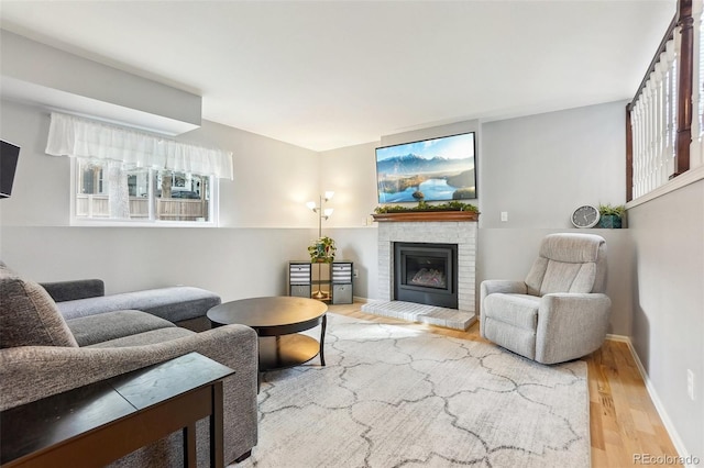 living area with wood finished floors and a brick fireplace
