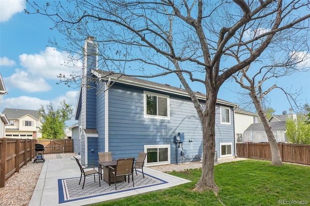 rear view of house with a patio and a chimney