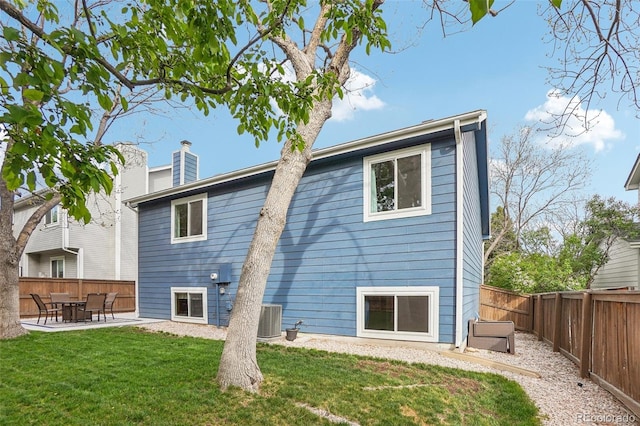 back of property with a patio, central air condition unit, and a chimney