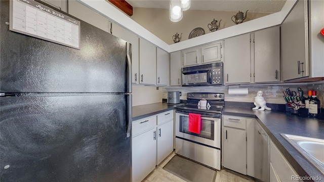 kitchen featuring black appliances, dark countertops, tasteful backsplash, and a sink