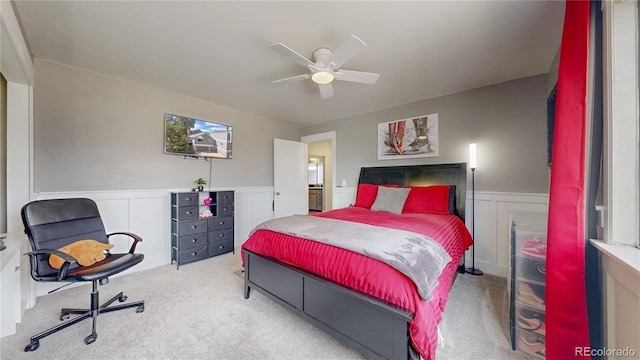 bedroom with carpet flooring, a wainscoted wall, and ceiling fan