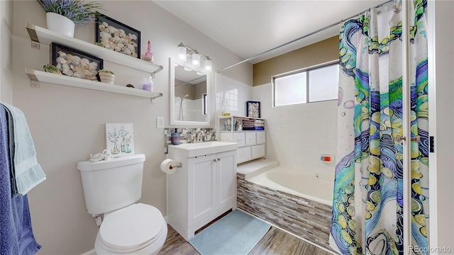 bathroom with tiled shower / bath combo, toilet, wood finished floors, and vanity