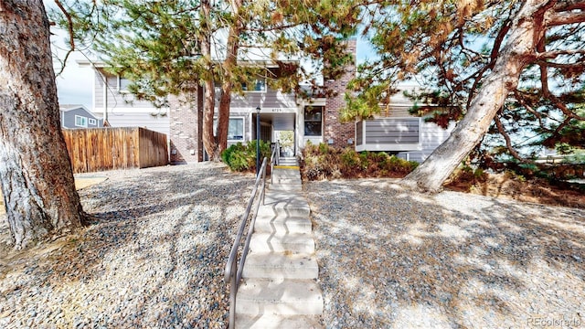 view of front of property featuring brick siding and fence