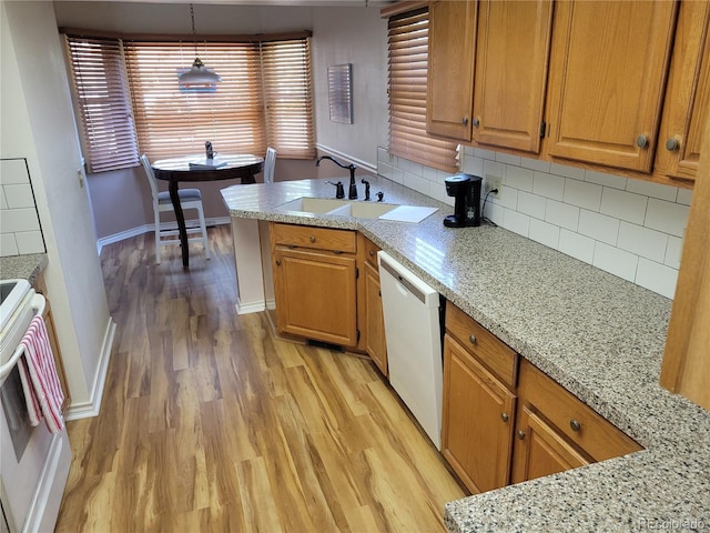 2619 S Iris Ct, Lakewood, CO 80227 - kitchen featuring white dishwasher, light wood finished floors, stove, a sink, and decorative backsplash