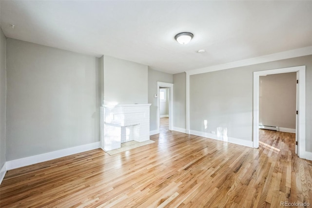 unfurnished living room with light hardwood / wood-style floors and a baseboard radiator