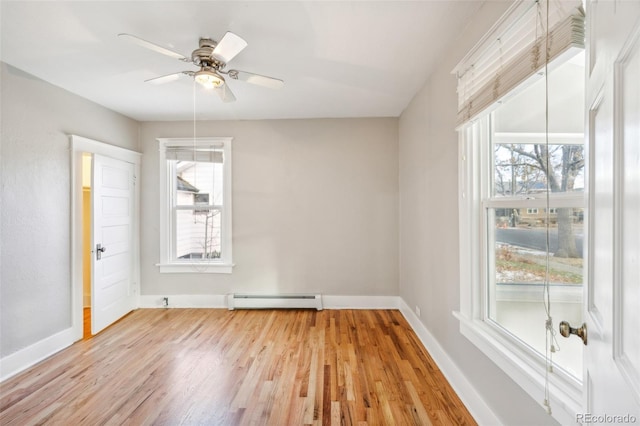 spare room featuring ceiling fan, light hardwood / wood-style flooring, and a baseboard heating unit