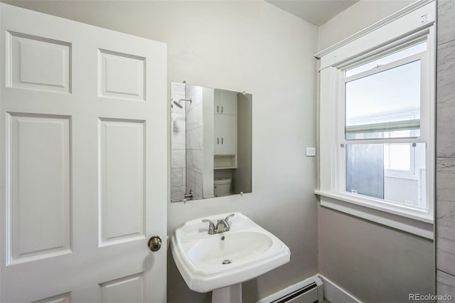 bathroom with toilet, plenty of natural light, a baseboard radiator, and sink