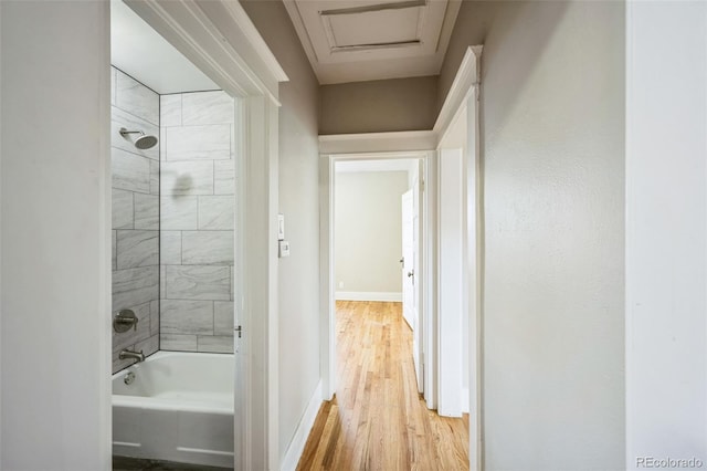 bathroom with hardwood / wood-style floors and tiled shower / bath