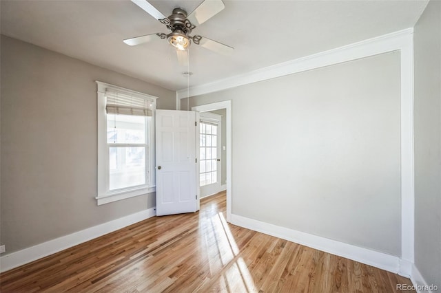 spare room with wood-type flooring, ceiling fan, and crown molding