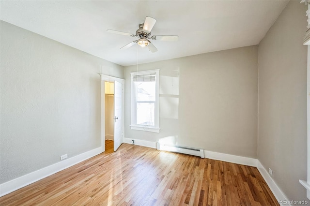 unfurnished room with ceiling fan, wood-type flooring, and a baseboard radiator