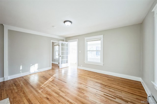 spare room featuring light wood-type flooring and a baseboard radiator