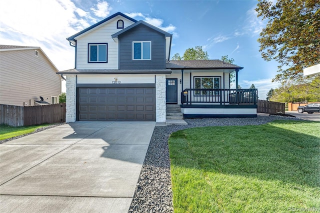 traditional home with a garage, driveway, fence, and a front yard