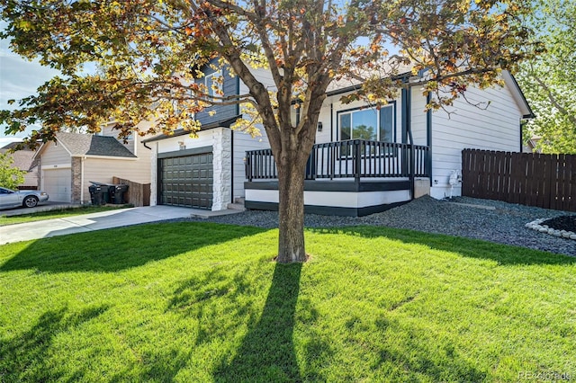 view of property hidden behind natural elements featuring fence, a garage, a front lawn, and driveway