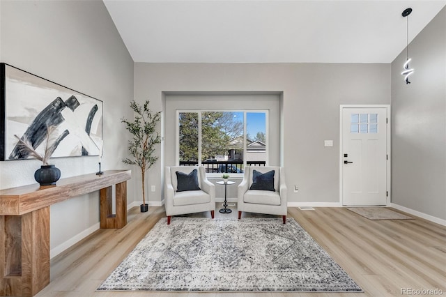 living area featuring baseboards and light wood-type flooring