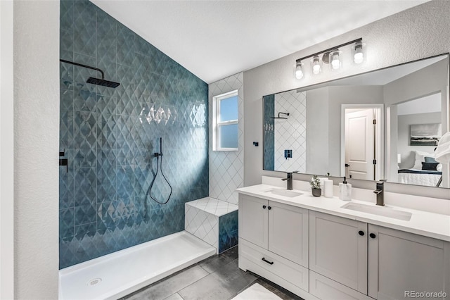 full bathroom with walk in shower, double vanity, and a sink
