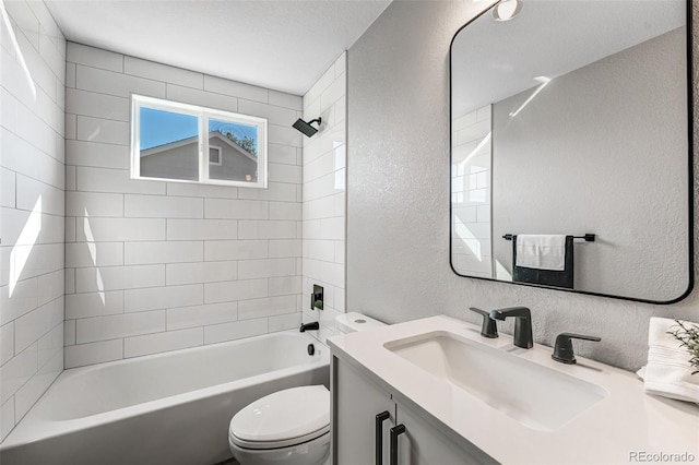 full bath with toilet, vanity, tub / shower combination, and a textured wall
