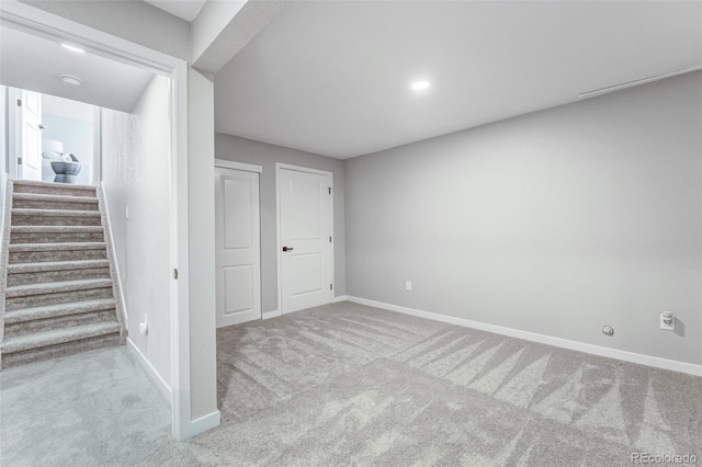below grade area with carpet, baseboards, and stairs