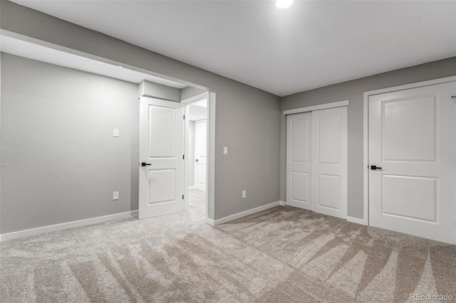 unfurnished bedroom featuring carpet flooring, a closet, and baseboards