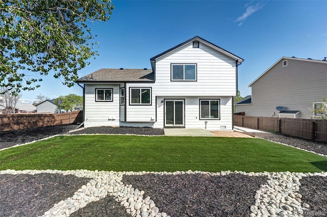 rear view of property with a yard, roof with shingles, a patio area, and a fenced backyard