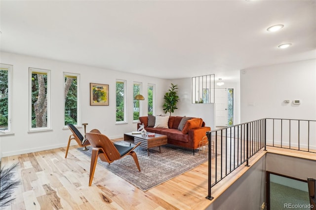 living room featuring light wood-style floors, baseboards, and recessed lighting
