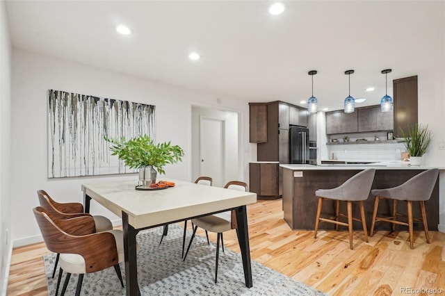 dining area with light wood-type flooring and recessed lighting
