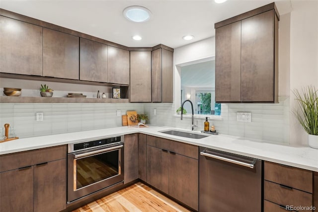 kitchen with stainless steel appliances, open shelves, a sink, backsplash, and recessed lighting