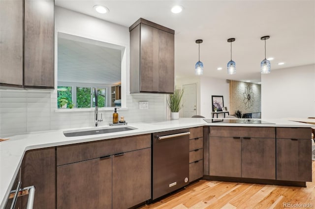 kitchen featuring stainless steel dishwasher, a sink, decorative backsplash, light countertops, and recessed lighting