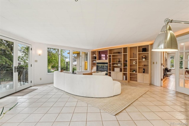 living area featuring light tile patterned flooring and built in shelves