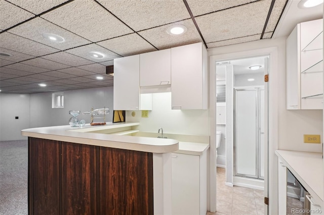 kitchen with white cabinets, light countertops, a peninsula, recessed lighting, and light tile patterned floors