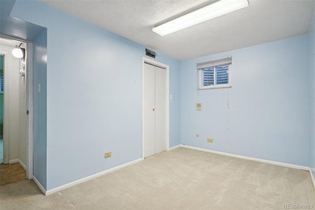 unfurnished room with light carpet and baseboards