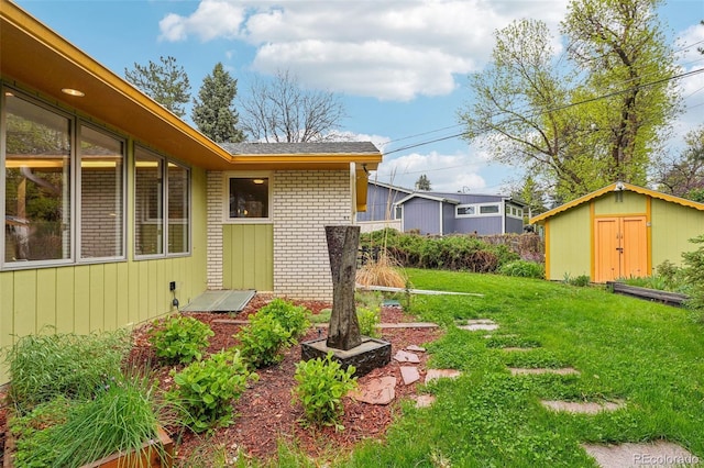 view of grassy yard featuring a shed and an outdoor structure