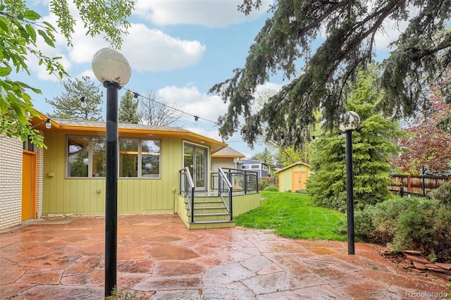 view of patio featuring a shed, an outbuilding, and a deck