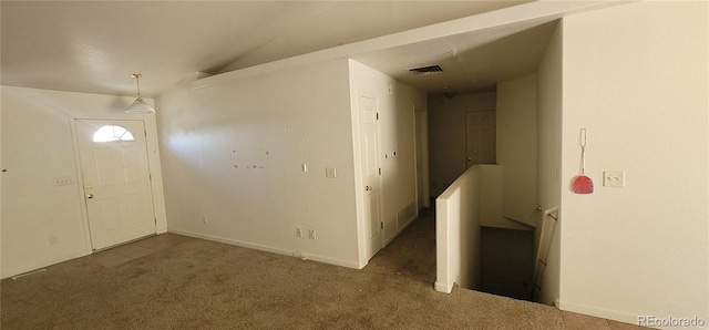 carpeted foyer featuring lofted ceiling