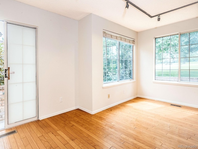 13894 E Lehigh Ave Unit G, Aurora, CO 80014 - empty room with rail lighting, light wood-type flooring, and baseboards