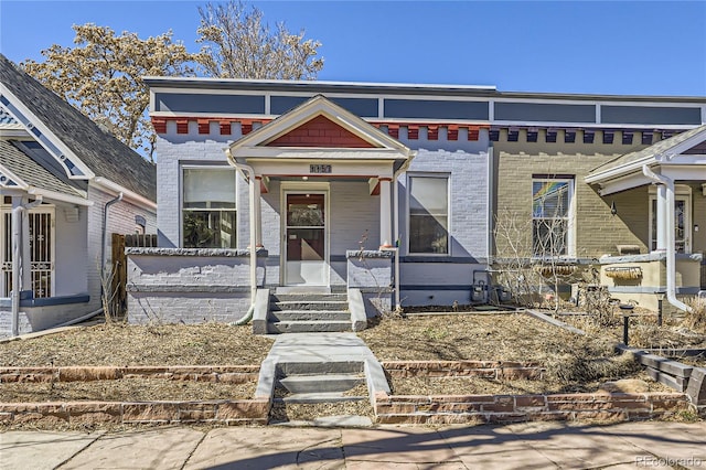 view of front of home featuring brick siding and a porch