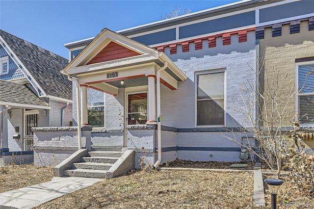 view of front of house with brick siding and a porch