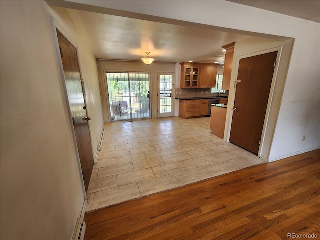 6525 E Harvard Ave, Denver, CO 80224 - kitchen featuring dark countertops, brown cabinetry, dishwasher, backsplash, and glass insert cabinets