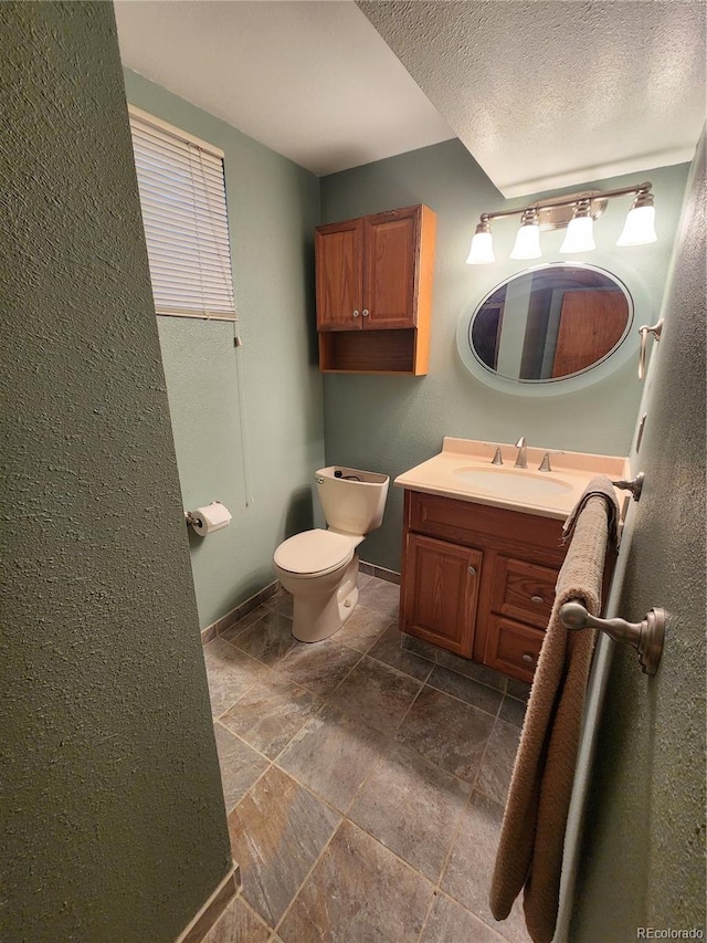 6525 E Harvard Ave, Denver, CO 80224 - bathroom featuring stone tile flooring, vanity, and a textured ceiling