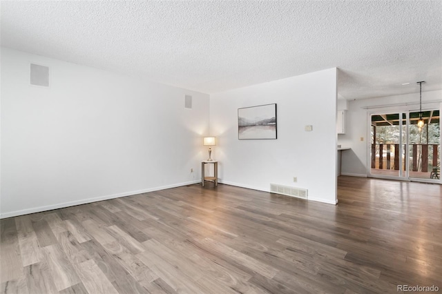 spare room featuring wood-type flooring and a textured ceiling