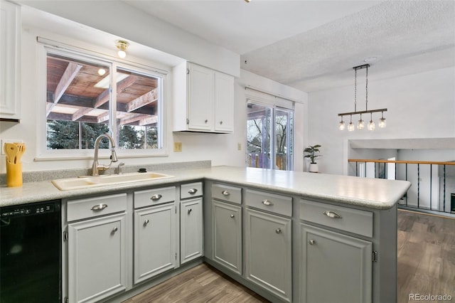 kitchen with dishwasher, sink, decorative light fixtures, kitchen peninsula, and gray cabinets