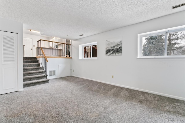 unfurnished living room with carpet floors and a textured ceiling