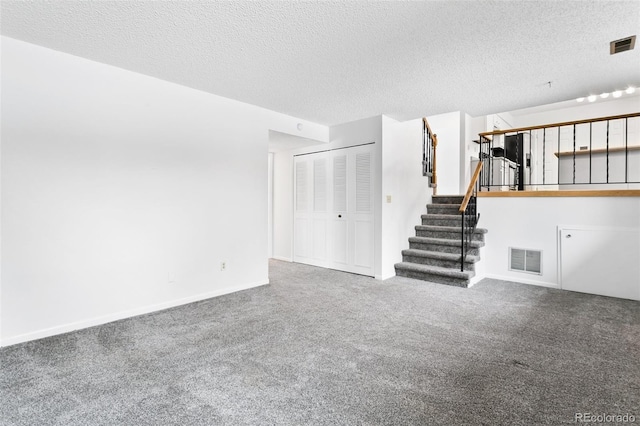 unfurnished living room with carpet and a textured ceiling