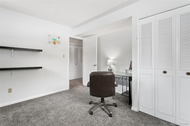 office area featuring a textured ceiling and dark colored carpet