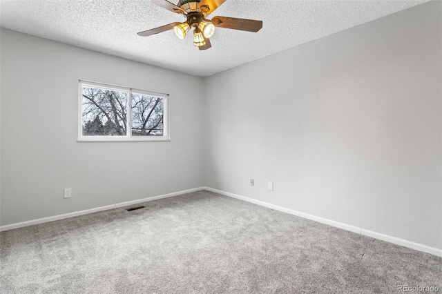 carpeted empty room featuring ceiling fan and a textured ceiling