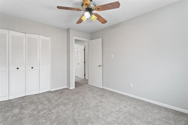 unfurnished bedroom with ceiling fan, light colored carpet, a textured ceiling, and a closet