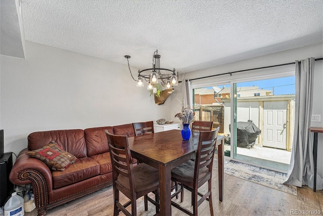 8666 Mariposa St, Thornton, CO 80260 - dining area featuring a notable chandelier, light wood-style flooring, and a textured ceiling