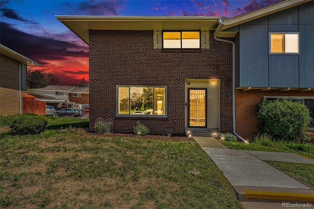 8666 Mariposa St, Thornton, CO 80260 - view of front of house with a yard, board and batten siding, and brick siding