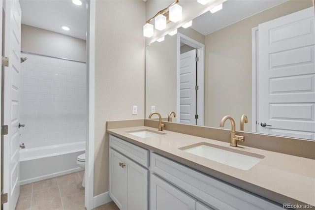 full bathroom featuring vanity, toilet, tiled shower / bath combo, and tile patterned flooring