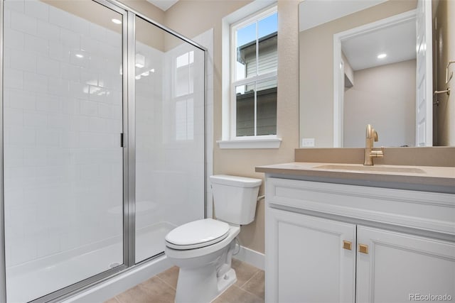 bathroom featuring vanity, toilet, a shower with door, and tile patterned flooring