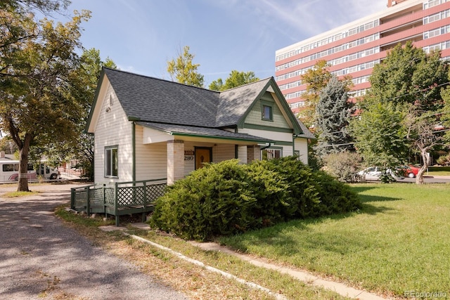 exterior space featuring a shingled roof and a lawn